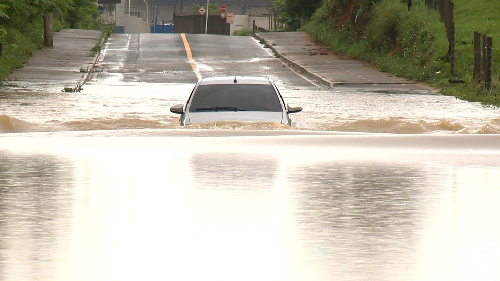Carro praticamente submerso pela água em trecho de estrada em Viana, ES - Foto: Reprodução/TV Gazeta